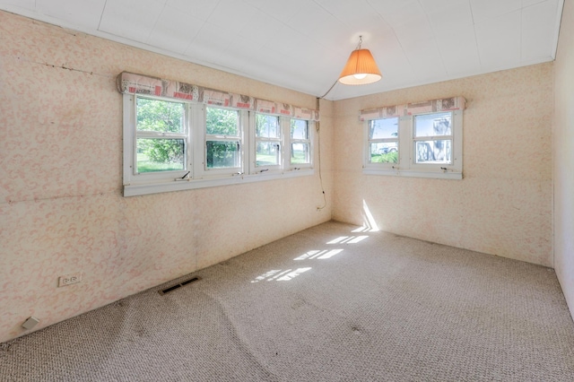 empty room featuring carpet flooring and wallpapered walls