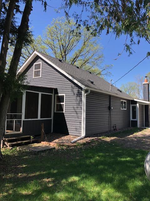 view of home's exterior featuring a sunroom, a chimney, and a yard