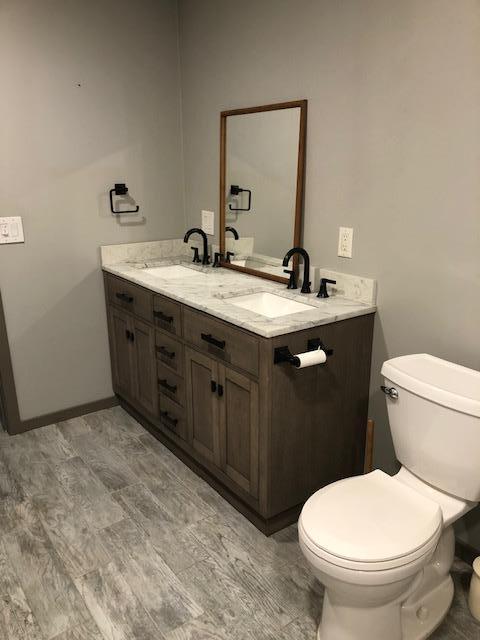 bathroom featuring toilet and double vanity