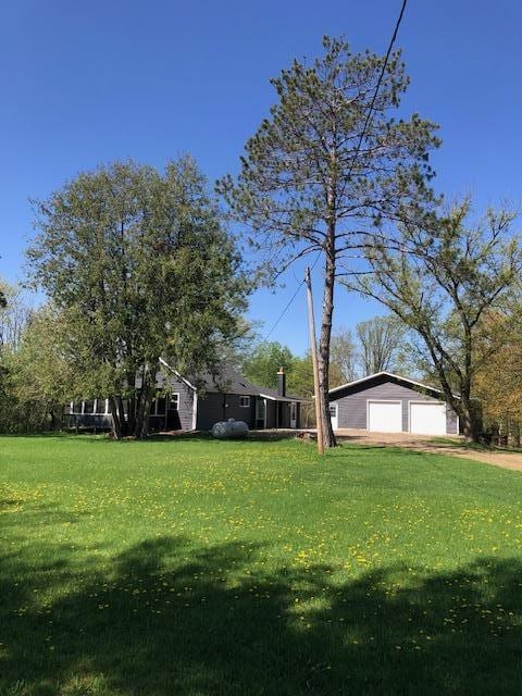 view of green lawn with a detached garage