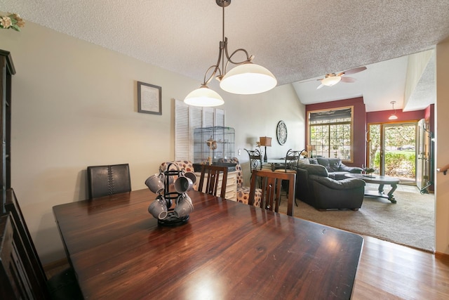 dining area with a textured ceiling, ceiling fan, and wood finished floors