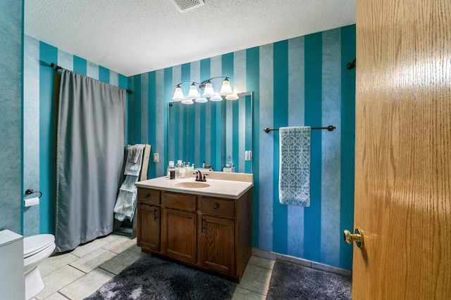 bathroom featuring toilet, vanity, a textured ceiling, wallpapered walls, and tile patterned floors