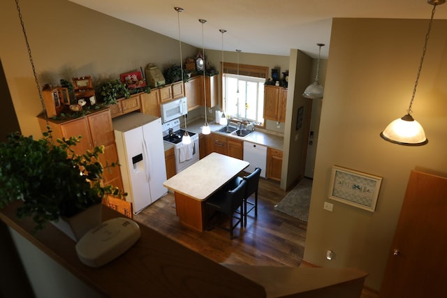 302 Pine St, Cannon Falls, MN 55009 - kitchen featuring white appliances, dark wood-type flooring, hanging light fixtures, a kitchen bar, and vaulted ceiling