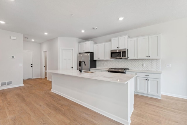20104 78th Pl, Corcoran, MN 55340 - kitchen featuring appliances with stainless steel finishes, a center island with sink, white cabinetry, decorative backsplash, and recessed lighting