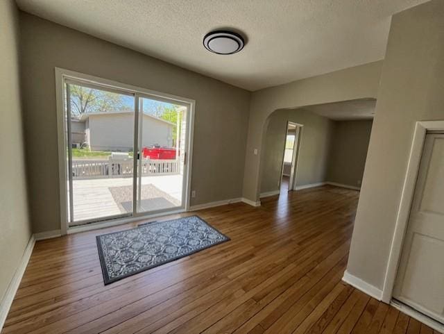 400 Main St W, Morristown, MN 55052 - entryway featuring arched walkways, wood finished floors, a textured ceiling, and baseboards