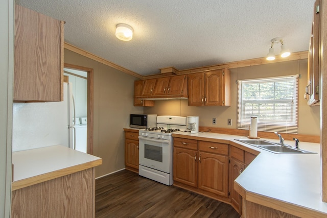 kitchen with white gas stove, dark wood finished floors, a textured ceiling, a sink, and washer / dryer