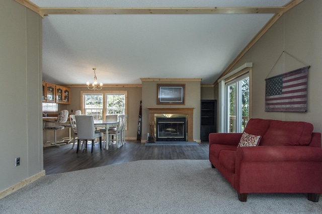 carpeted living room with a chandelier, healthy amount of natural light, baseboards, and a glass covered fireplace