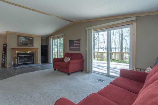 living room featuring carpet floors, a premium fireplace, lofted ceiling, and baseboards