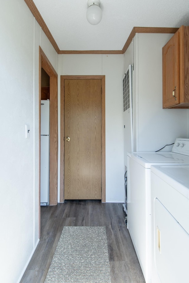 washroom featuring cabinet space, washer and dryer, wood finished floors, crown molding, and a heating unit