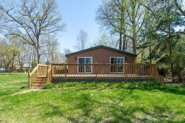 back of house with a wooden deck and a lawn