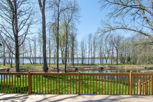 deck with a water view and a yard