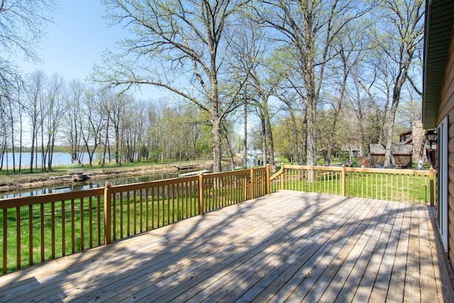 wooden deck featuring a water view and a lawn