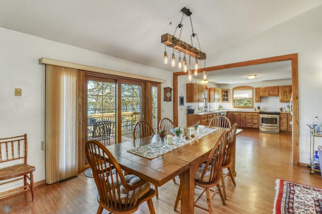 dining space featuring light wood finished floors and baseboards
