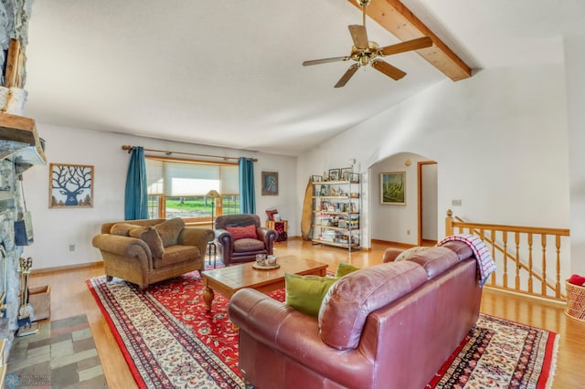 living room featuring a ceiling fan, wood finished floors, and arched walkways