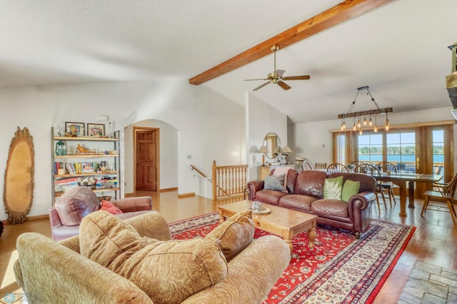 living room featuring arched walkways, ceiling fan, and wood finished floors