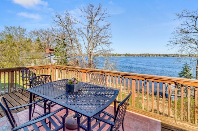 wooden terrace with outdoor dining area and a water view