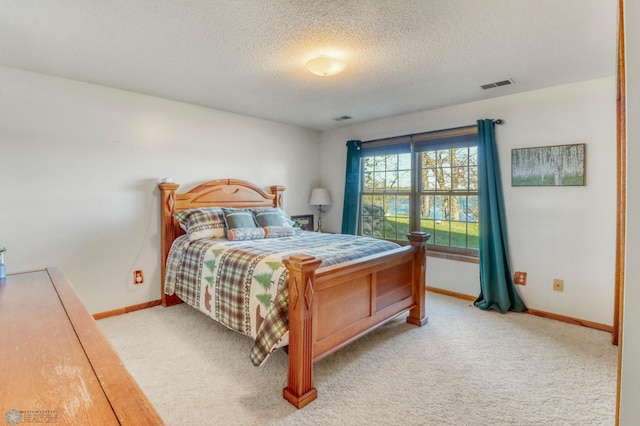 bedroom featuring baseboards, carpet flooring, and a textured ceiling