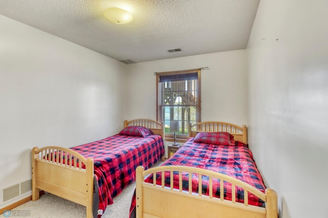 bedroom with carpet flooring, a textured ceiling, and baseboards