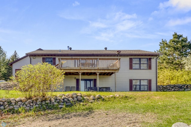 back of property featuring a wooden deck and a lawn
