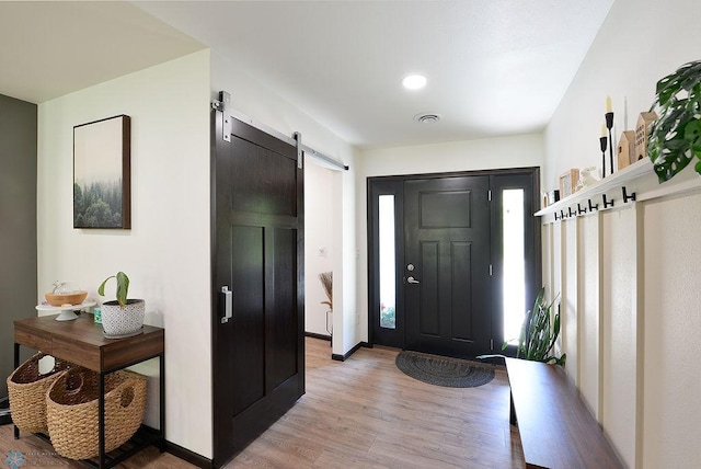 14840 Eaglewood Dr, Burlington Twp, MN 56501 - entrance foyer featuring a barn door, light wood-type flooring, and baseboards