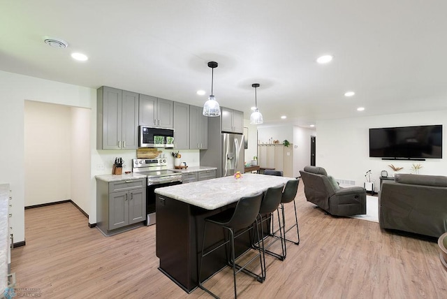 14840 Eaglewood Dr, Burlington Twp, MN 56501 - kitchen with appliances with stainless steel finishes, gray cabinets, a kitchen bar, light wood-style floors, and a kitchen island