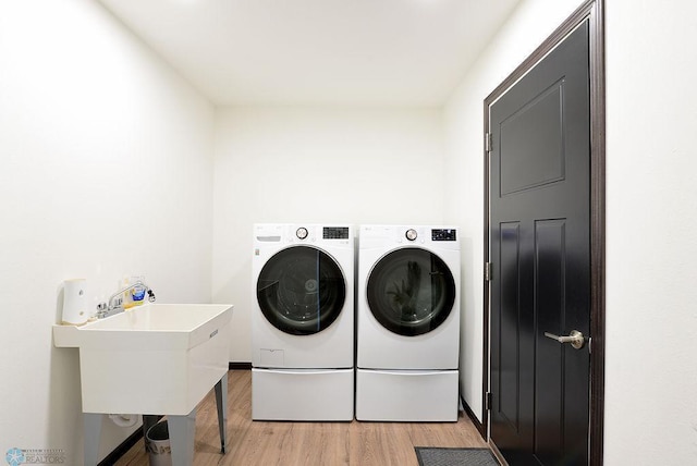 14840 Eaglewood Dr, Burlington Twp, MN 56501 - laundry room with washer and clothes dryer and light wood-type flooring