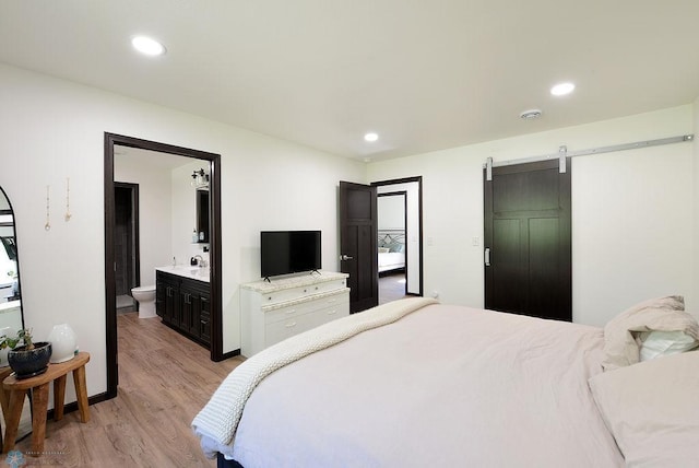 14840 Eaglewood Dr, Burlington Twp, MN 56501 - bedroom with light wood finished floors, a barn door, recessed lighting, ensuite bathroom, and a sink