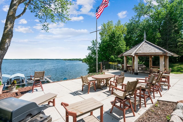 view of patio with a water view, a gazebo, and grilling area