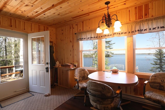 3291 Thomas Rd, Greenwood Twp, MN 55790 - dining space featuring a chandelier, wood walls, plenty of natural light, and a water view