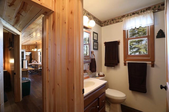 3291 Thomas Rd, Greenwood Twp, MN 55790 - bathroom featuring toilet, vanity, wood finished floors, a chandelier, and wooden ceiling