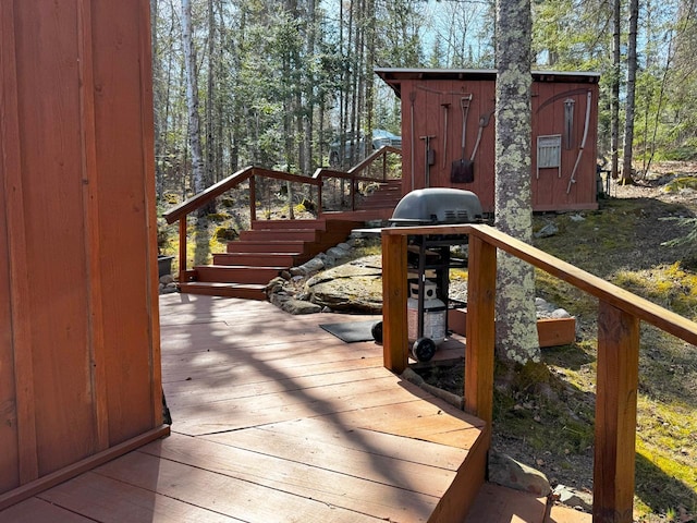3291 Thomas Rd, Greenwood Twp, MN 55790 - wooden terrace featuring stairs, a storage unit, and an outdoor structure
