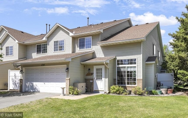 1785 Riverwood Dr, Burnsville, MN 55337 - view of front of property with driveway, a front lawn, an attached garage, and a shingled roof