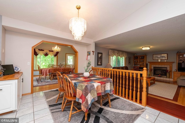 155 Palomino Ln, Lino Lakes, MN 55014 - dining room with a chandelier, a tile fireplace, and lofted ceiling