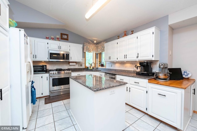 155 Palomino Ln, Lino Lakes, MN 55014 - kitchen with appliances with stainless steel finishes, lofted ceiling, decorative backsplash, white cabinets, and a sink