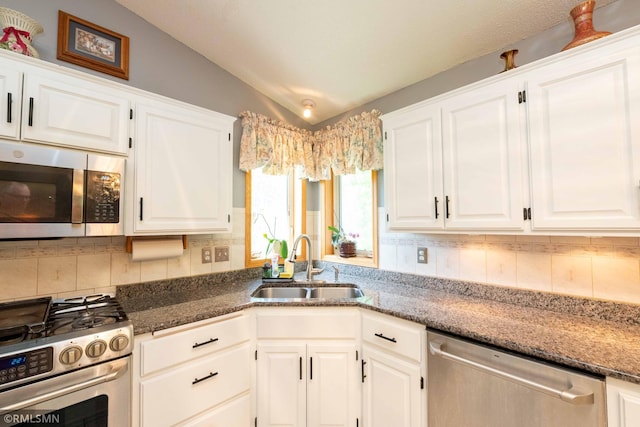 155 Palomino Ln, Lino Lakes, MN 55014 - kitchen with appliances with stainless steel finishes, a sink, vaulted ceiling, white cabinets, and tasteful backsplash