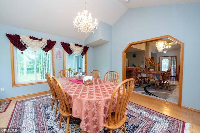 155 Palomino Ln, Lino Lakes, MN 55014 - dining area featuring a chandelier, vaulted ceiling, wood finished floors, arched walkways, and baseboards