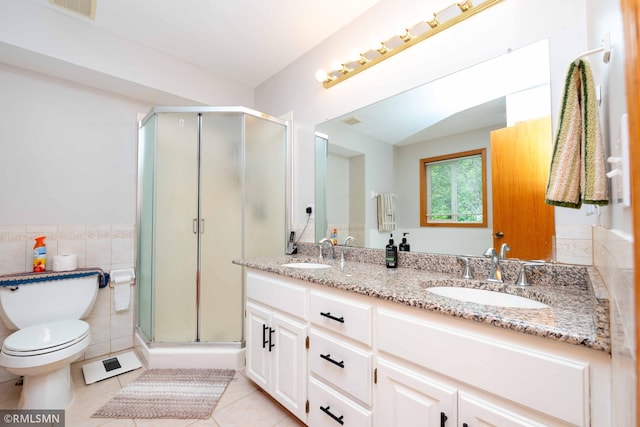 155 Palomino Ln, Lino Lakes, MN 55014 - bathroom featuring tile patterned floors, double vanity, toilet, a shower stall, and tile walls