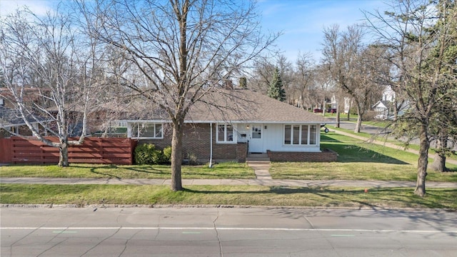 515 23rd St, Hibbing, MN 55746 - view of front of home with a front lawn, brick siding, and a shingled roof