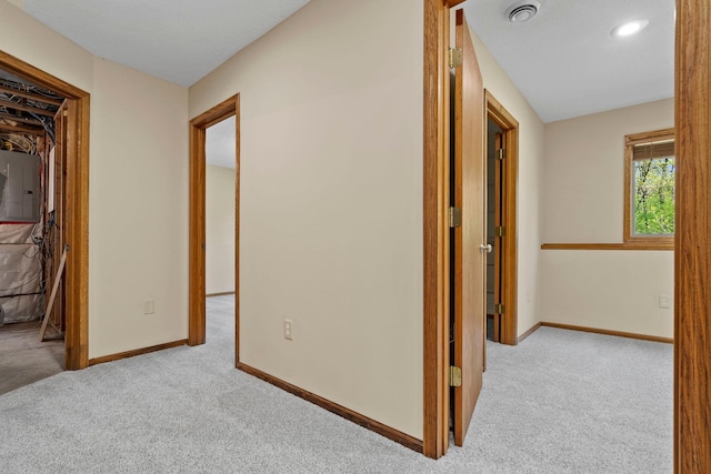 corridor featuring carpet floors, electric panel, baseboards, and recessed lighting