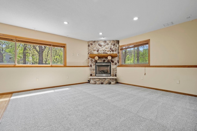 unfurnished living room featuring baseboards, a fireplace, carpet floors, and recessed lighting