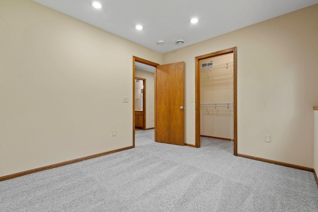 unfurnished bedroom with carpet flooring, baseboards, recessed lighting, a spacious closet, and a closet