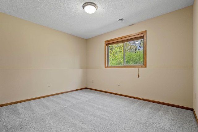 unfurnished room with carpet floors, baseboards, and a textured ceiling
