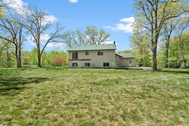 rear view of property featuring a lawn and a wooden deck