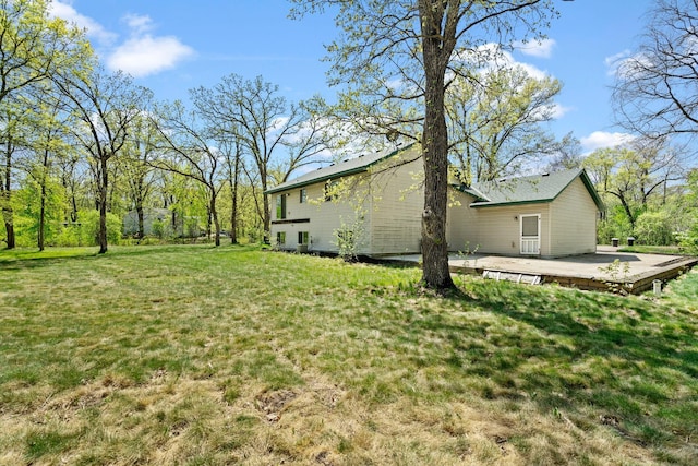view of green lawn featuring a wooden deck
