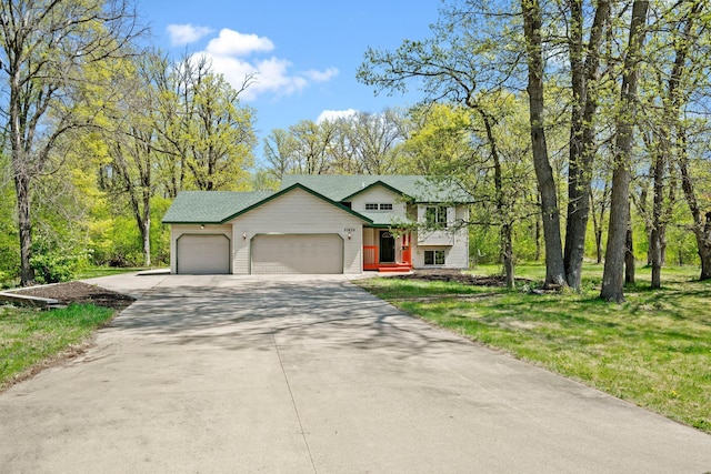 view of front of house with a garage, driveway, and a front yard