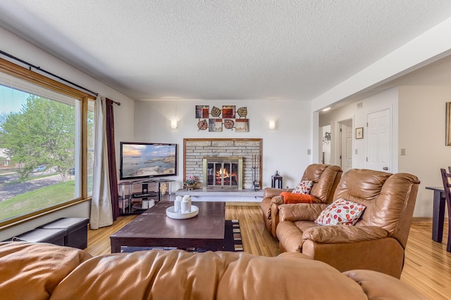 998 Saint Paul Ave, Saint Paul, MN 55116 - living room featuring a textured ceiling, light wood-type flooring, and a brick fireplace
