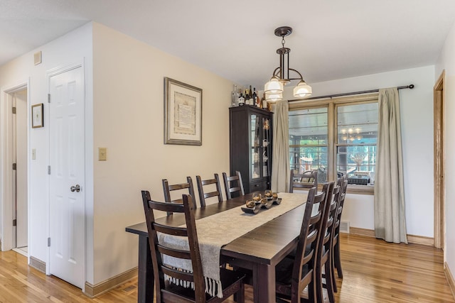998 Saint Paul Ave, Saint Paul, MN 55116 - dining space with light wood finished floors, baseboards, and a chandelier