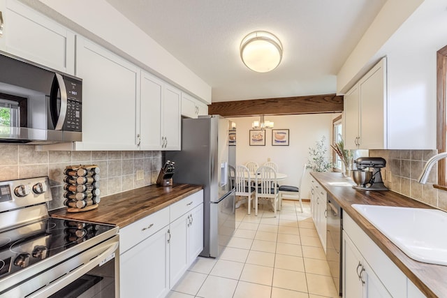 998 Saint Paul Ave, Saint Paul, MN 55116 - kitchen featuring wooden counters, stainless steel appliances, a sink, a chandelier, and white cabinetry