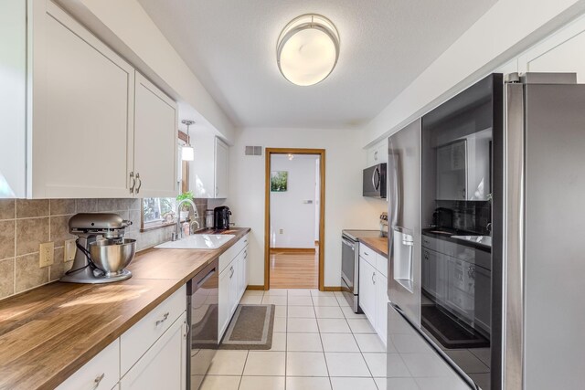 998 Saint Paul Ave, Saint Paul, MN 55116 - kitchen with appliances with stainless steel finishes, wooden counters, a sink, tasteful backsplash, and white cabinetry