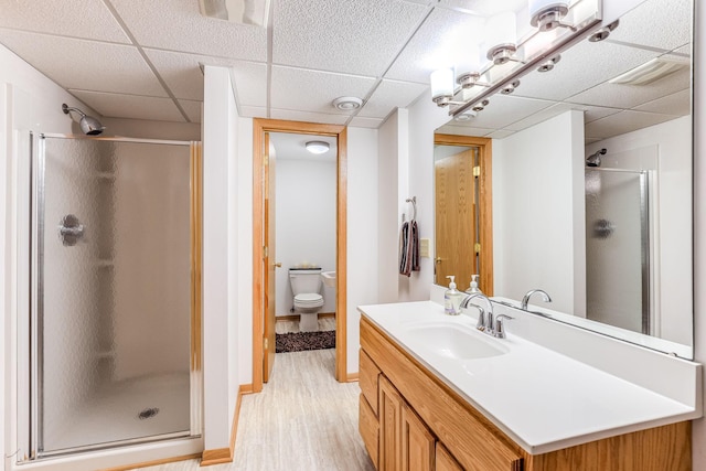 998 Saint Paul Ave, Saint Paul, MN 55116 - bathroom with wood finished floors, a stall shower, a drop ceiling, vanity, and toilet